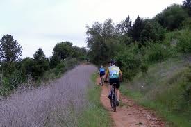 Two people cycling on a dirt track in the countryside