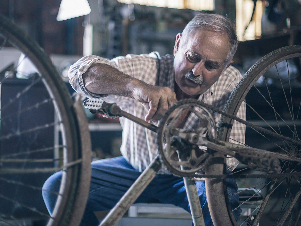 man fixing an old bicycle