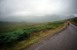 Cyclist in remote hills covered in low cloud