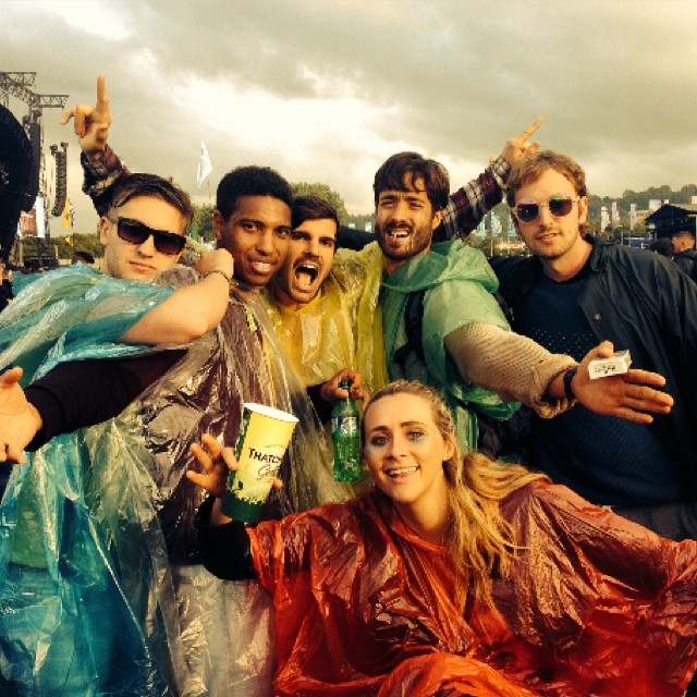 group of people in rain ponchos at a festival